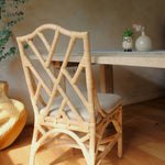 Rattan chair with a cushion in a room with a table and decorative items.