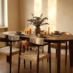 Wooden chair with woven seat in a room with wooden floor and plant- Walnut colour.